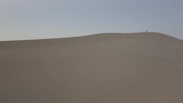 Aerial Drone Shot of Group of People Walking on Sand Dune in Death Valley