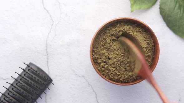 The Wooden Bowl with Rehydrated Henna Power on Table