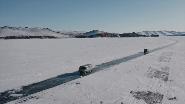 Two Off-road Cars Ride on the Ice of Frozen Lake Baikal Aerial Surveying