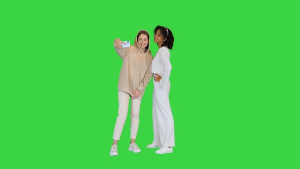 African American and a Caucasian Girl Taking a Selfie on a Green Screen Chroma Key