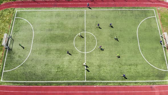 Aerial View Children Play Football on a Small Football Field. Modern Football Ground Near the School