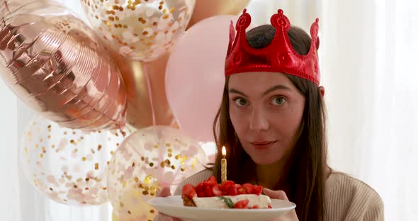 Woman Blows Out the Candle on the Cake