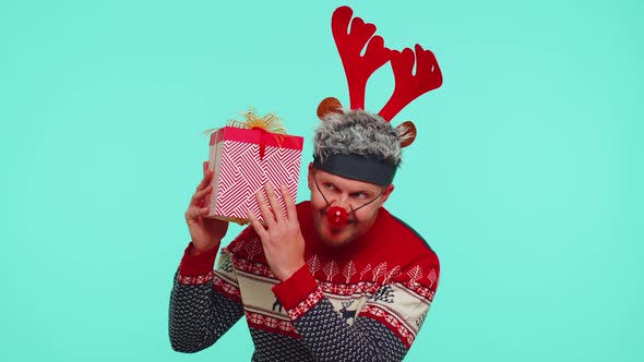 Funny Man Wears New Year Sweater Deer Antlers Received Present Interested in What Inside Gift Box