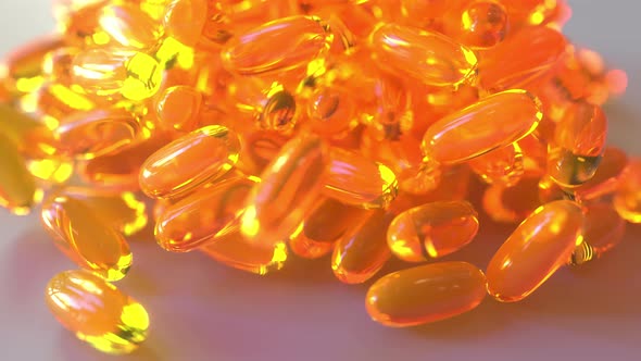 Pouring Fish Oil or Orange Drug Capsules on the Table