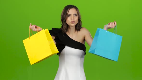 Girl Keeps the Shopping Bags and Doubts What To Choose. Green Screen