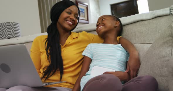 Mother and daughter sitting together in living room 4k