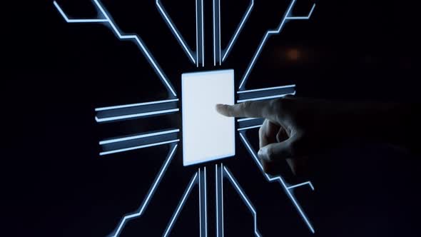 Human finger is pressing a digital button on a glowing touchscreen.