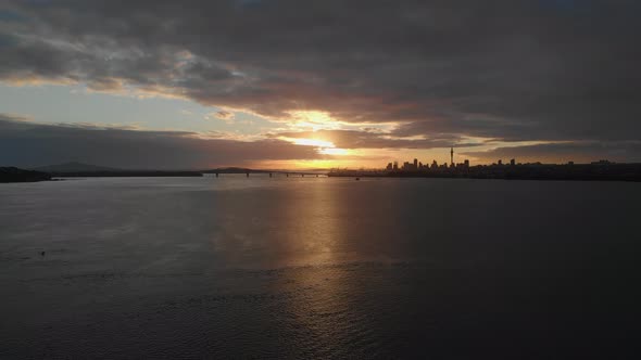 AERIAL, sunrise over Auckland Harbour Bridge and CBD skyline in New Zealand
