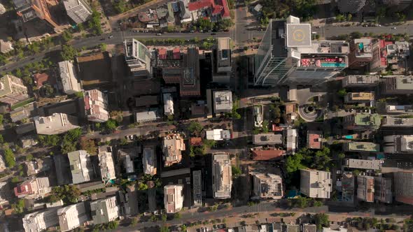 Aerial ascending over concrete jungle and building with helipad on a sunny afternoon in Santiago de