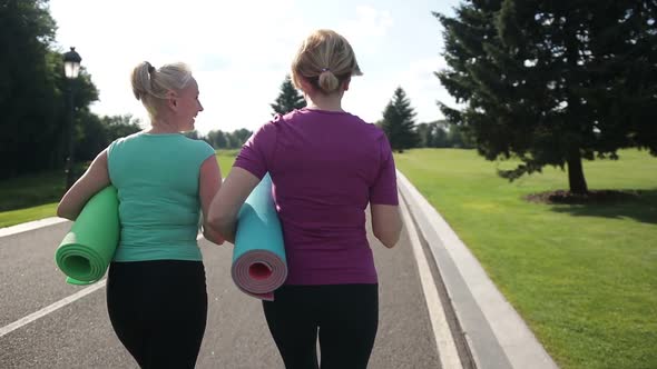 Fitness Women with Excercise Mats Going Training