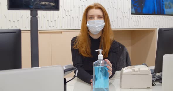 Female Seller in Mask Standing at Checkout and Giving Bottle with Antiseptic To Clients