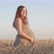 Pregnant happy red-haired woman touching her belly, future young mother walking at sunset - VideoHive Item for Sale