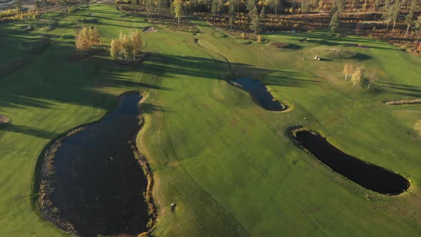 Revealing a beautiful golf course from high above with small lakes, bunkers and fairways.