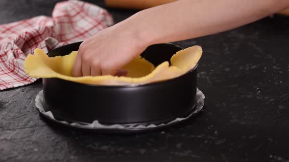 A Girl Puts the Dough in a Cake Mold at Home in the Kitchen