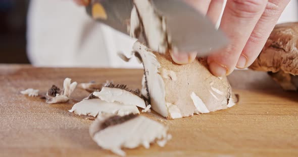 Close up of a chef knife slicing a portobello mushroom