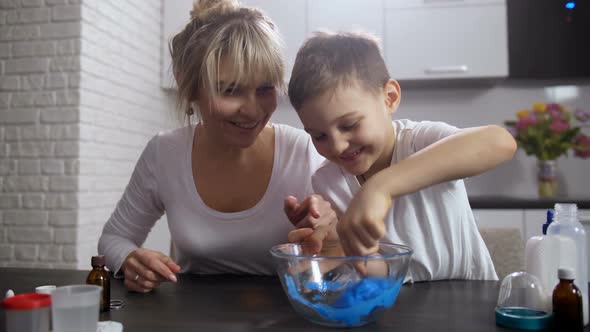 Little Smiling Boy Actively Mixing Mass for Slime