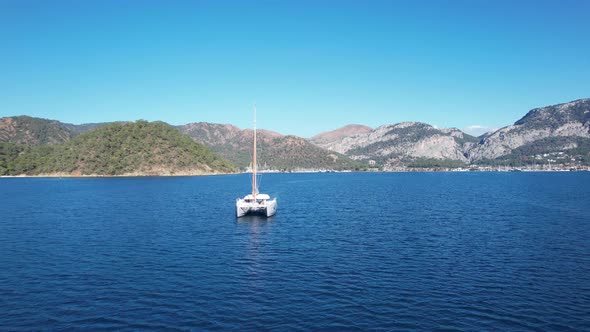 Catamaran Sail in Front of Mountains of Turkey By the Sea