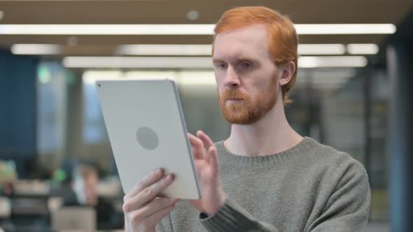 Portrait of Young Man Celebrating on Tablet in Office