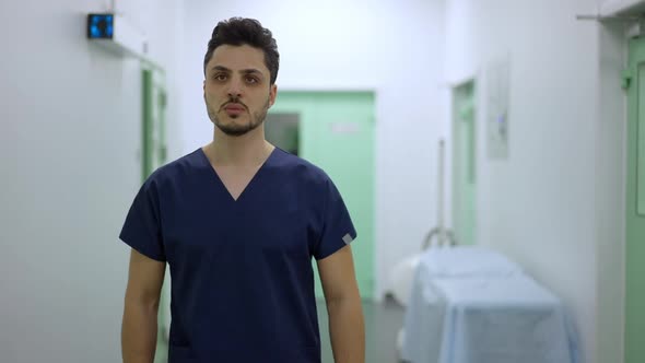 Medium Shot of Confident Serious Male Middle Eastern Surgeon Walking in Slow Motion in Clinic