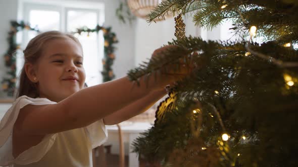 Cute girl decorating the Christmas tree. Shot with RED helium camera in 8K