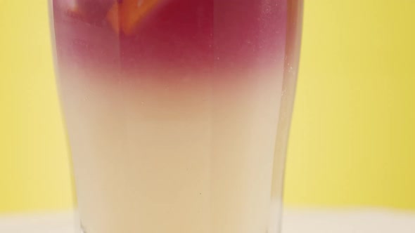 Summer Cocktail Glass of Lemonade Mint and Ice Cubes on a Yellow Background