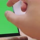 Man Touches and Looks at the Screen of the Black Smartphone with a Green Screen. Close Up - VideoHive Item for Sale