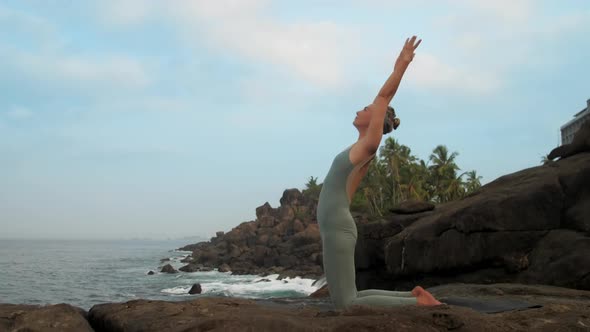 Girl Raises Hands Getting Into Ushtrasana at Sea Slow Motion