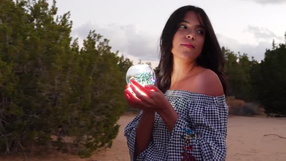 A gorgeous woman sorceress wandering in a fantasy landscape with a magical spiritual orb glowing in