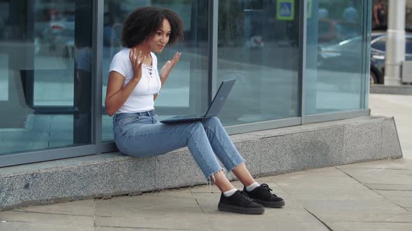 Young African Attractive Woman Chatting on Internet Over Laptop Pleasantly Surprised at Joy of