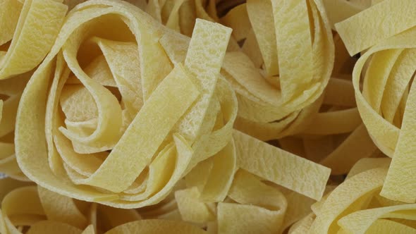 Close Up of Raw Pasta Rotate on Board. Fettuccine, Tagliatelle Pasta. Italian Cuisine. Food