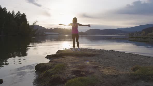 Adventurous Woman on a Shore Enjoying Colorful Sunset