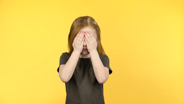 Cute Child with Red Hair Have Fun Covers Her Face with Hands