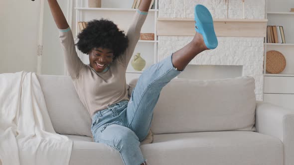 Happy Relaxed African American Young Adult Black Woman Rest Alone on Comfortable Sofa at Home Hold