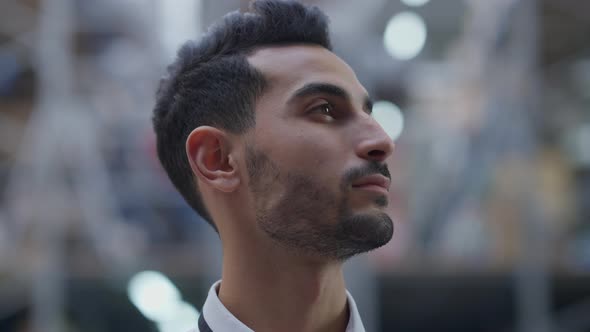 Headshot Portrait of Bearded Concentrated Middle Eastern Handsome Man Looking Around Indoors