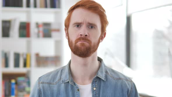 Portrait of Sad Casual Redhead Man Upset By Loss