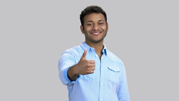 Portrait of Cheerful Happy Darkskinned Man Shows Like Gesture