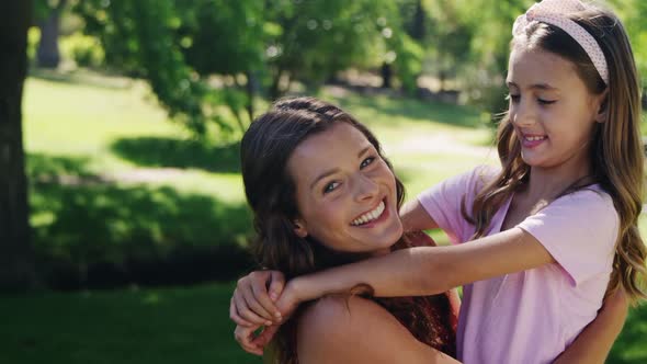 Mother embracing her daughter in the park