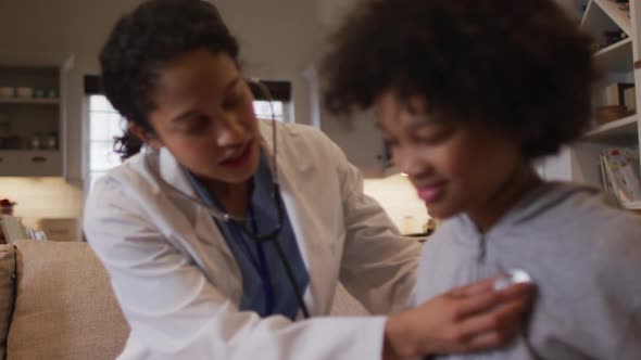 Mixed race female doctor examining mixed race girl at home