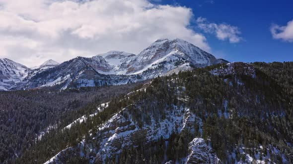 Flying around snow capped mountain in Utah during winter