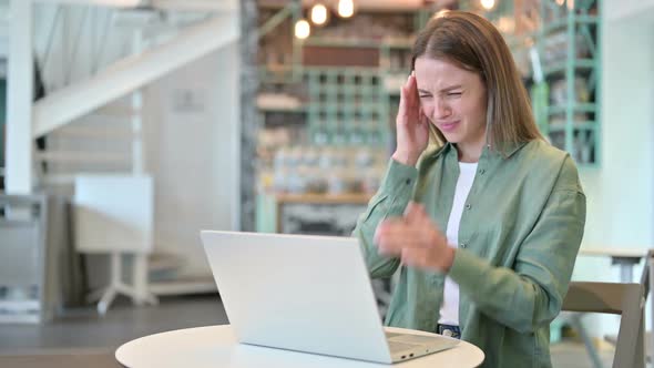 Stressed Woman with Laptop Having Headache in Cafe