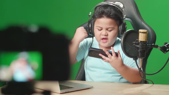 Asian Boy Playing Video Game With Mobile Phone Then Celebrating While Live Stream On Green Screen