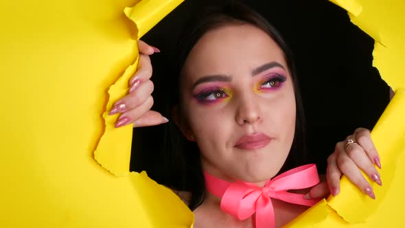 A Beautiful Young Girl Model with a Bright Juicy Yellow Fashion Makeup and a Pink Bow Around Her