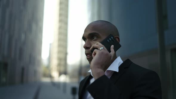 Serious African businessman talking by phone