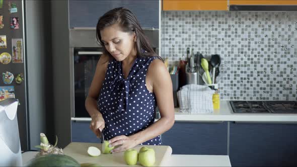 Woman Cutting Apples on Board in Kitchen