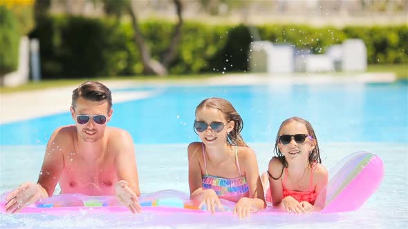 Father and Two Kids Enjoying Summer Vacation in Luxury Swimming Pool