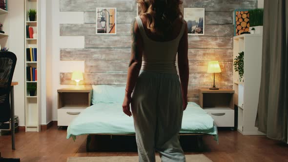 Beautiful Blonde Woman in Pajamas Dropping Back on Her Bed