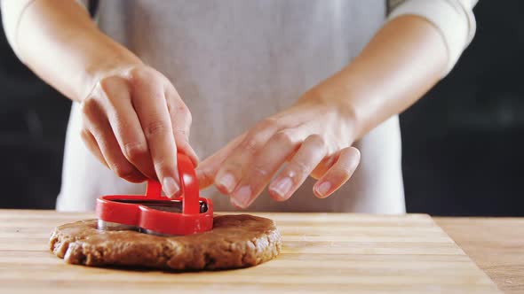 Woman molding gingerbread dough on wooden board