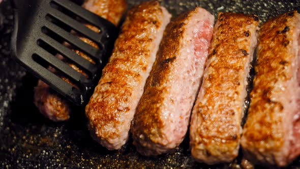 Pink Sausages are Fried on a Grill Pan