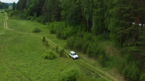 Aerial View of a Car Driving Along the River Bank