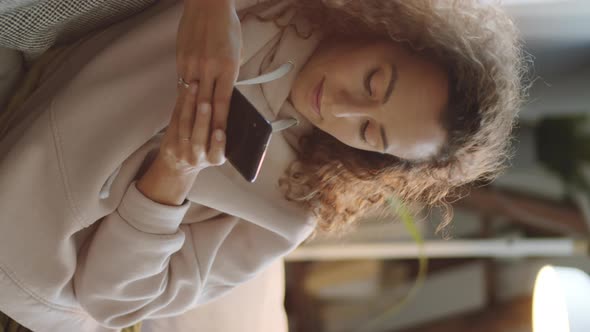 Young Lady Using Smartphone on Sofa at Home